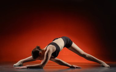 Stüdyo zemininde kırmızı gradyan ve fotokopi alanı bir fitness sitesi afişi ya da sosyal reklam için geniş bir bakış açısı var..