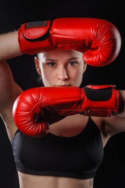 Stüdyoda yakın plan bir kadın boksör portresi, kırmızı eldivenli savunma görevlisi, sosyal reklamlar, fitness siteleri ve boks eğitimi promosyonu için uygun..