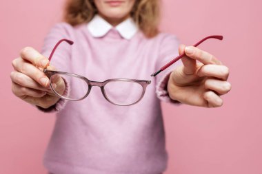 Hasarlı gözlük takan kolları kopmuş bir kadın, göz giysisi tamiri gereksinimini vurguluyor. Optik hizmetler, sigorta pazarlama, sağlık desteği ve perakende kampanyaları için ideal.