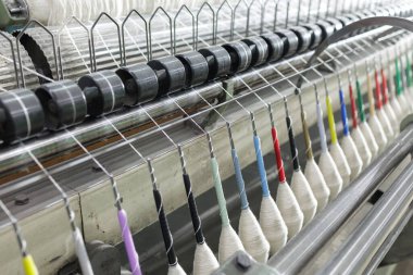 Dokuma tezgahı sistemine yönlendirilen warp ipliklerinin kapatılması, kumaş imalatı ve endüstriyel pazarlama kullanımı için hassas tekstil dokuma sürecini göstermektedir..