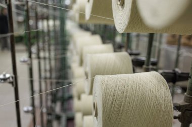 Tekstil imalatı, tedarik zinciri ve endüstriyel üretim pazarlama için ideal, otomatik dokuma sistemine iplik sağlayan hizalı iplik makaraları.