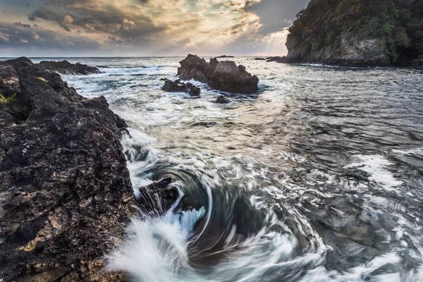 岩のビーチに泡沫サーフ — ストック写真