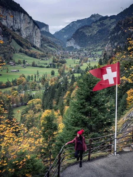 スイス国旗に山を背景にポーズをとる女性は — ストック写真