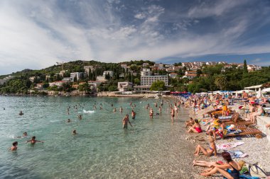 Kumsalda güneşlenirken insanlar