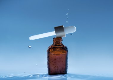 Mavi su arka plan damla ve pipet ile Anti-yaş serum nemlendirici
