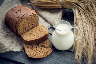 Çavdar ekmeği arpa demet ve ahşap arka plan üzerinde süt sürahi ile