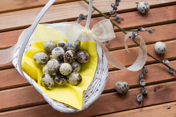 Quail eggs on yellow napkin in white wicker basket — Stock Photo, Image