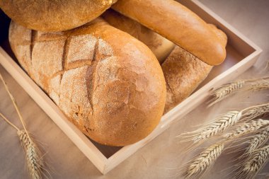 Ahşap tepsi çeşitli ekmek buğday kulakları ile dolu