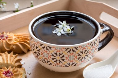 Kiraz eriği çiçek ve kurabiye kurabiye ile siyah çay bardak 