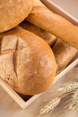 Çeşitli ekmek ve buğday spikelets ile ahşap tepsi