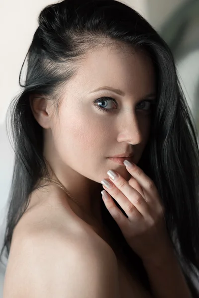 Emotional portrait of beautiful brunet girl with blue eyes, clean skin, long hair and bare shoulder — Stock Photo, Image