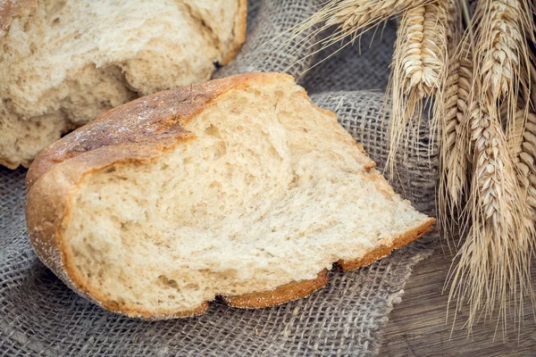 Quebre a crosta de pão com um ramo de trigo. Foco selectivo — Fotografia de Stock