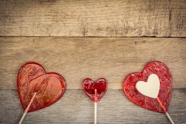 Ahşap arka plan, hippi tarzı bir kalp şeklinde üç lolipop