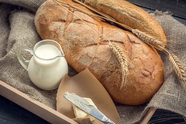 Pão branco fresco com jarro de leite — Fotografia de Stock