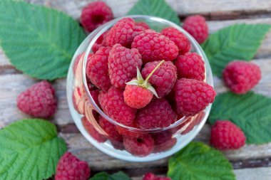 Lezzetli ahududu saydam vazo içinde seyir üzerinde ahşap tablo, closeup vurdu