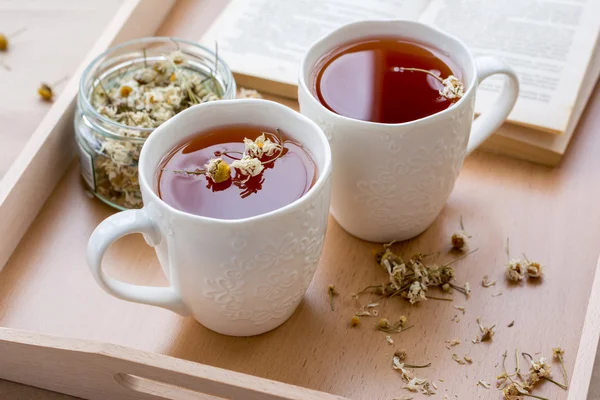 Tisane aux fleurs de camomille sur plateau en bois — Photo