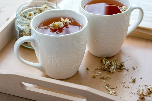 Две белые чашки с травяным чаем на деревянном подносе — стоковое фото