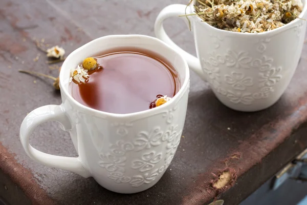 Tasse de thé à la camomille sur fond brun — Photo