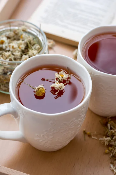 Tisane à base de camomille dans des tasses en céramique sur plateau en bois — Photo