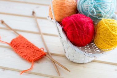 Arka plan beyaz hasır sepet ile iplik skeins ve eksik örgü tasarı