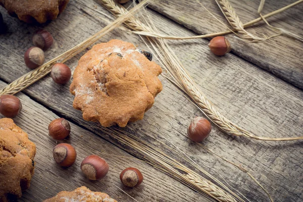 Torte, nocciole e spighe di orzo su fondo rustico in legno — Foto Stock
