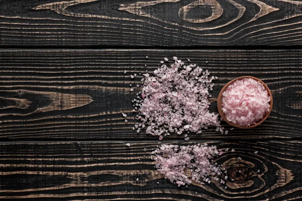 Pink Himalayan salt crystals in a wooden bowl  on black wood bac — Stock Photo, Image