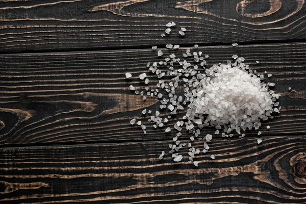 White salt on black wood background — Stock Photo, Image