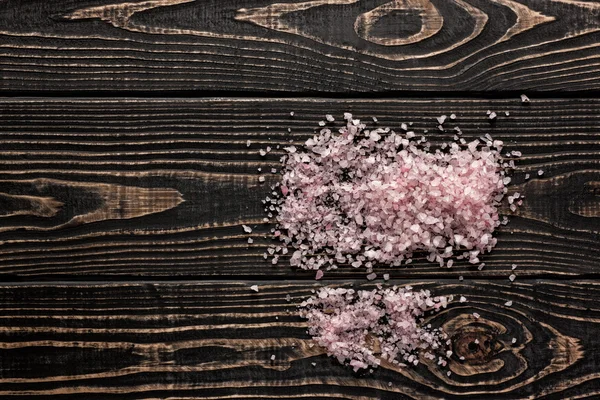 Розовая гималайская соль на фоне черного дерева — стоковое фото