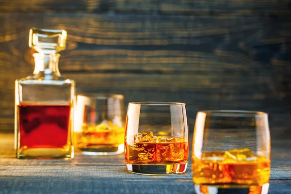 glasses of scotch whiskey on a wooden background, selective focu