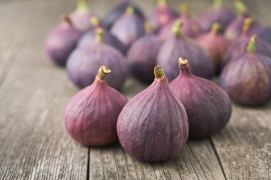 Kırsal bir zemin üzerinde olgun mor incirler, seçici odak.