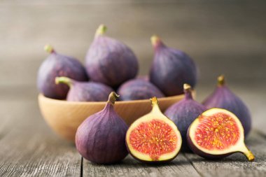 Köy arka planında ahşap bir kasede taze incir..