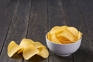 Kırsal bir masada seramik bir kasede gevrek patates cipsi ve metin için kopya alanı..