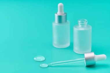 Mavi arka planda bir doz sıvı hyaluronik asit, seçici odak.