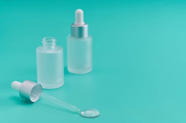 Mavi arka planda bir doz sıvı hyaluronik asit, seçici odak.