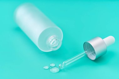 Mavi arka planda bir doz sıvı hyaluronik asit, seçici odak.