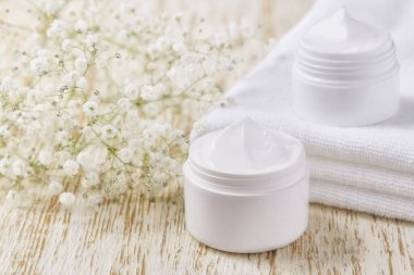 Ahşap bir masada beyaz bir kavanozda nemli losyon ya da vücut kremi, metin için boşluk kopyala.