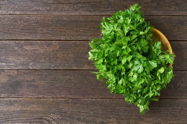 Masadaki ahşap bir kasede çiğ organik maydanoz, metin için kopyalama alanı. rustik biçim.