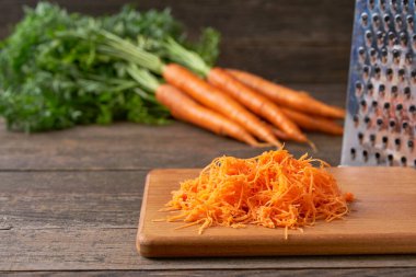 Kesme tahtasında rendelenmiş organik havuç, seçici odak, kırsal tarzda.