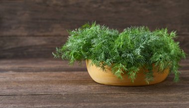 Masadaki ahşap bir kasede çiğ organik dereotu, seçici odak, kırsal tarzda..