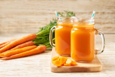 Kavanoz bardakta taze havuç suyu. Ahşap bir masaya karşı malzemeleri olan sahne. Taze havuç püresi. .