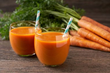 Kırsal ahşap bir masada gözlüklü taze havuç püresi, seçici bir odak. Sağlıklı detoks diyeti.