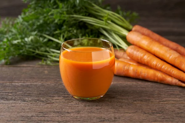 Kırsal ahşap bir masada gözlüklü taze havuç püresi, seçici bir odak. Sağlıklı detoks diyeti.