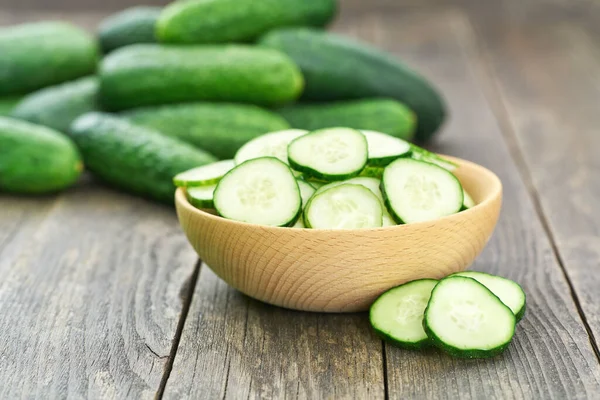 organic cucumbers in a wooden bowl on a wooden table, rustic style. Fresh cucumber. lot of cucumbers in a wooden bowl.