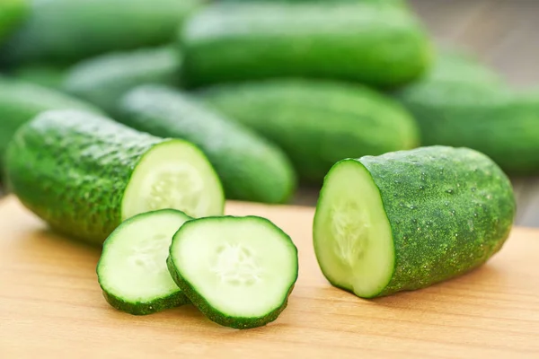 Ganze Und Scheiben Geschnittene Frische Gurken Auf Einem Schneidebrett — Stockfoto