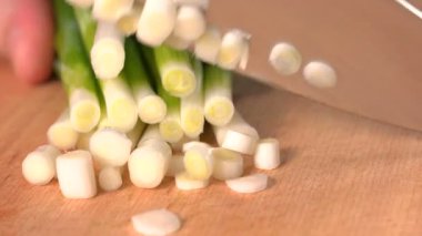 Kesme tahtasındaki taze taze soğanı kesiyorum. Taze taze soğan doğruyorum. Kapatın..