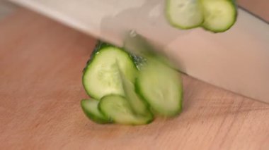 Kesme tahtasıyla taze salatalık kesiyorum. Taze salatalık doğruyorum. Yakından..