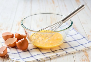 Omlet pişirme işlemi, yakın çekim. Kahvaltı için çırpılmış taze yumurta pişiriyorum. Bir kase yumurta ve pişirmek için çırpılmış çırpılmış yumurta. .