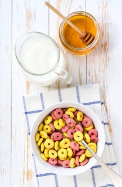 Bir kase lezzetli mısır gevreği. Meyve aromalı, sütlü ve ballı. Mutfak masasında. Kahvaltıda atıştırmalık sağlıklı..