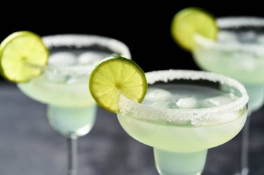 Siyah bir masada limon ve tuzla süslenmiş klasik margarita kokteyli..