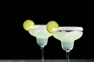 Margarita kokteyli bardakta, limonlu ve buzlu siyah masada, yakın plan..